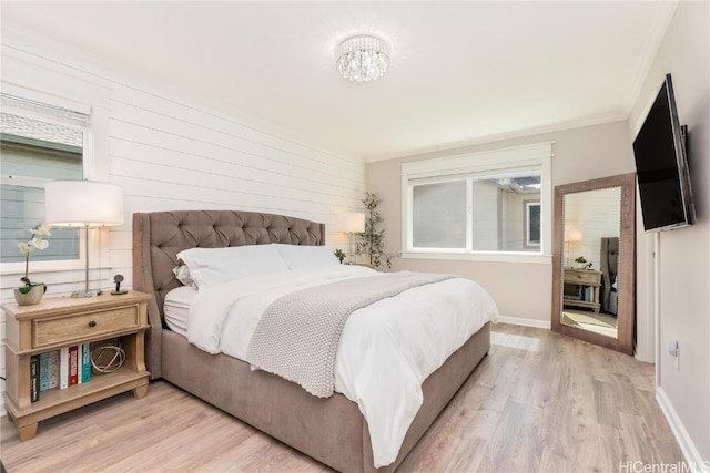 bedroom featuring light wood finished floors, baseboards, and ornamental molding