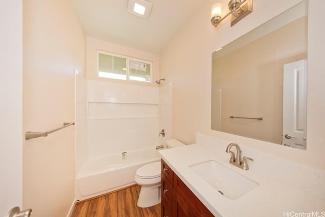 full bathroom featuring washtub / shower combination, vanity, wood finished floors, and toilet