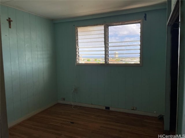 unfurnished room featuring dark wood-style floors and baseboards