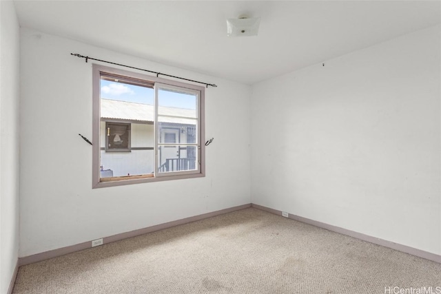 carpeted spare room with baseboards