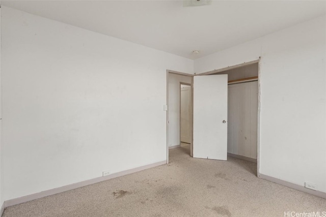 unfurnished bedroom featuring carpet flooring, baseboards, and a closet