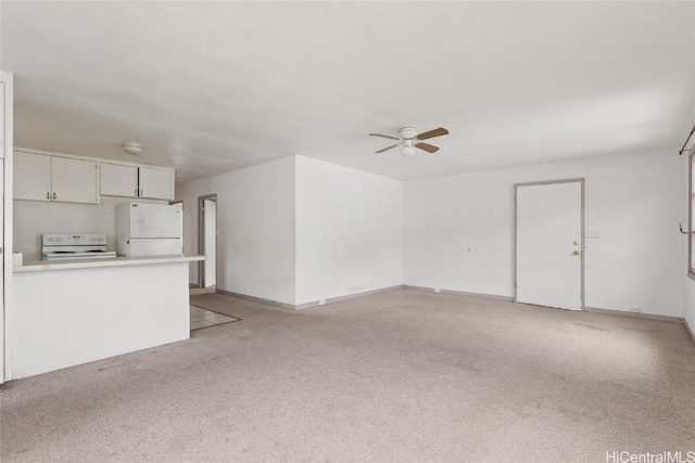 unfurnished living room featuring ceiling fan and light carpet