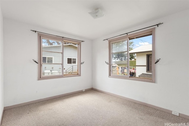 spare room with baseboards and carpet flooring