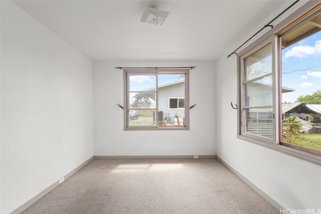 spare room with baseboards and carpet