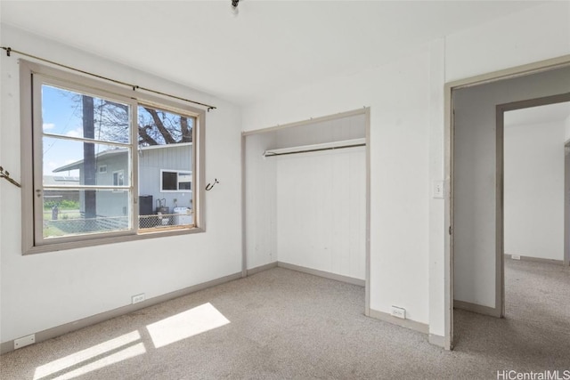 unfurnished bedroom featuring a closet, baseboards, and carpet