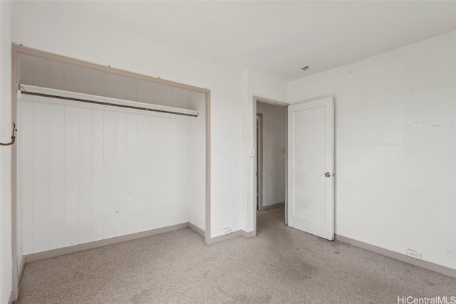 unfurnished bedroom with a closet, baseboards, and carpet flooring