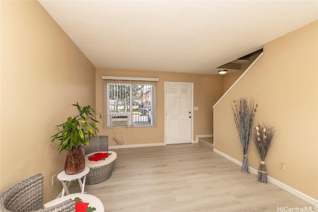 entryway featuring stairs, cooling unit, baseboards, and wood finished floors