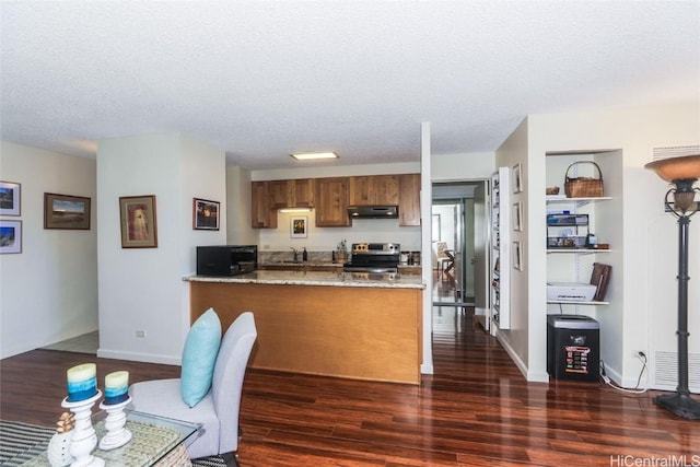 kitchen with dark wood-style floors, electric stove, a peninsula, black microwave, and under cabinet range hood