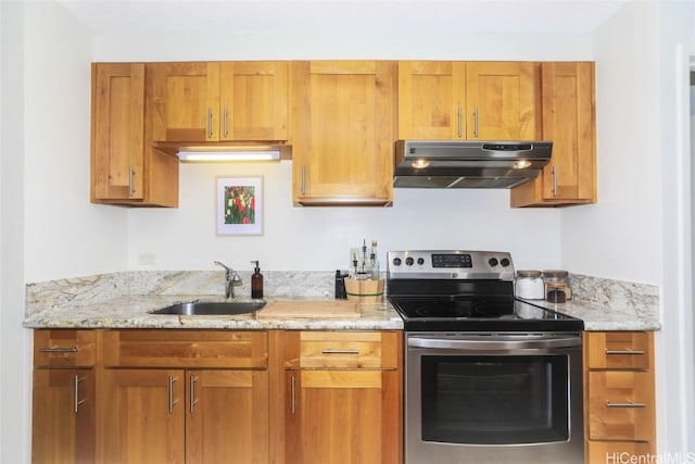 kitchen with brown cabinets, a sink, stainless steel range with electric stovetop, and under cabinet range hood