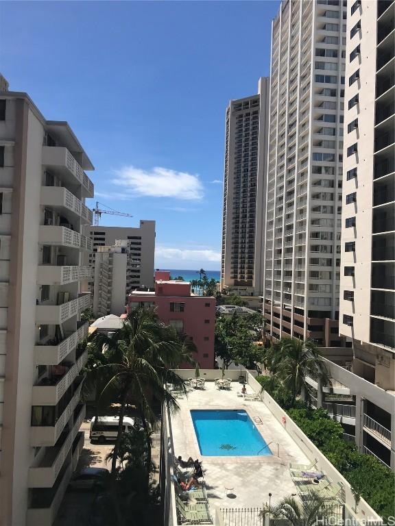 community pool with a city view and a patio