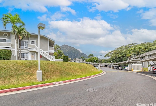 view of street featuring curbs, stairway, a residential view, and a mountain view