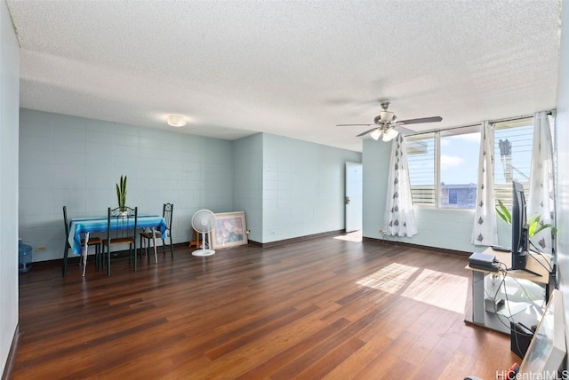 living area featuring a textured ceiling, wood finished floors, and a ceiling fan