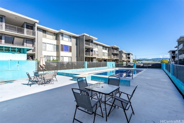 community pool featuring fence and a patio