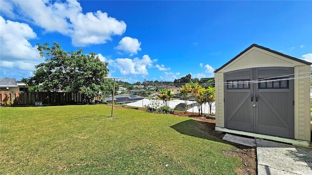 view of yard with an outbuilding, fence, and a shed