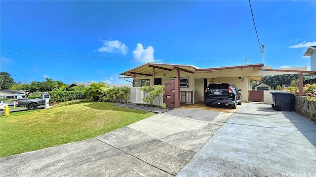 ranch-style home featuring a carport, a front yard, and driveway