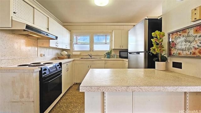 kitchen featuring dark floors, light countertops, a sink, a peninsula, and black appliances