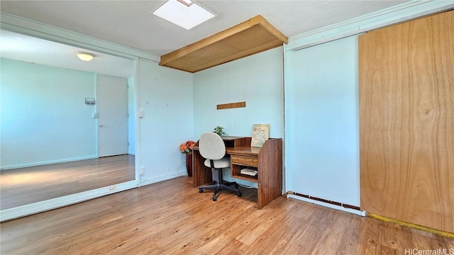 home office featuring a skylight, wood finished floors, and baseboards