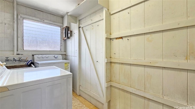 clothes washing area with laundry area, wooden walls, and washer / clothes dryer