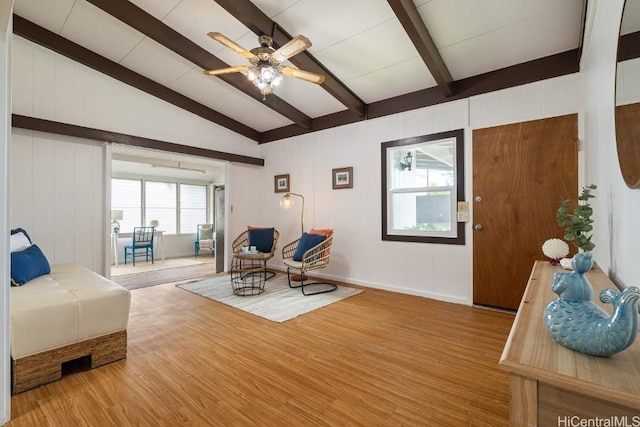 bedroom with lofted ceiling with beams and wood finished floors