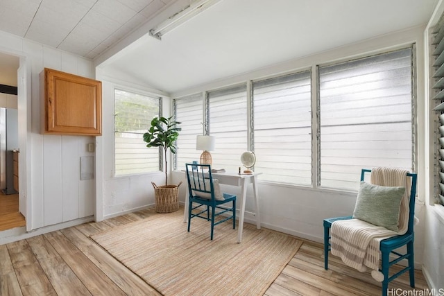 interior space with light wood-type flooring, lofted ceiling with beams, and baseboards