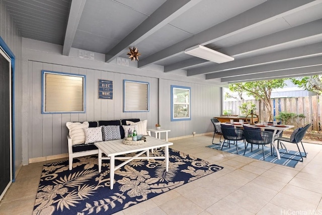 interior space with baseboards, beam ceiling, and tile patterned floors