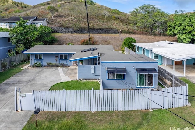 exterior space featuring a fenced front yard, a mountain view, and a lawn