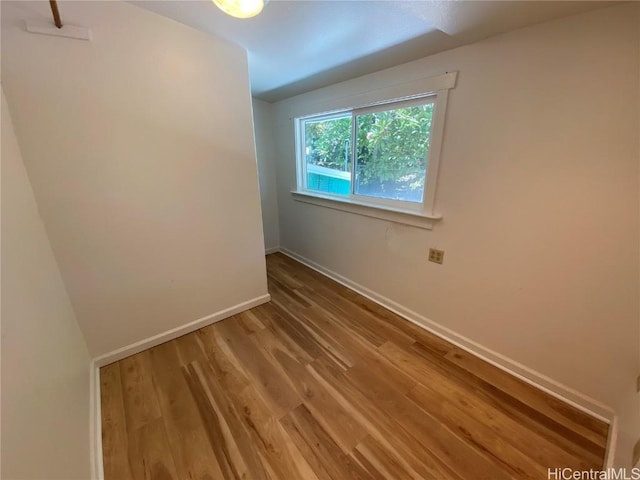 unfurnished room featuring baseboards and wood finished floors