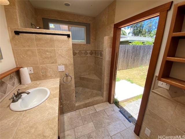 bathroom with stone tile flooring, vanity, and a walk in shower