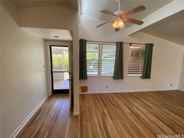 spare room featuring ceiling fan, wood finished floors, lofted ceiling, and baseboards