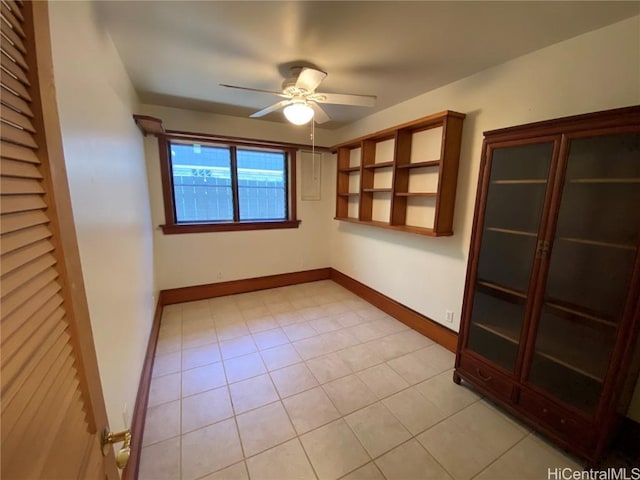 unfurnished room featuring ceiling fan, baseboards, and light tile patterned floors