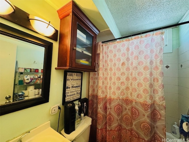 full bath with a textured ceiling, curtained shower, and toilet