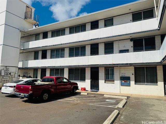 view of building exterior with uncovered parking