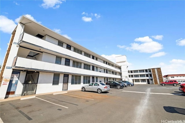 view of building exterior with uncovered parking