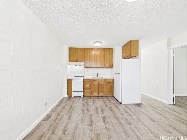 kitchen featuring brown cabinets, white appliances, light wood-type flooring, and light countertops