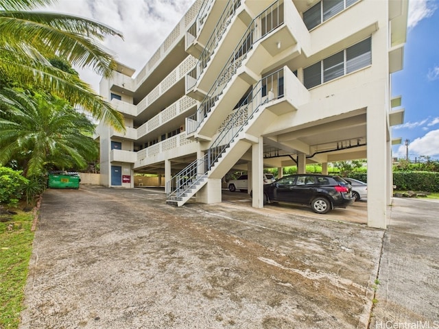 view of property with stairs and covered parking