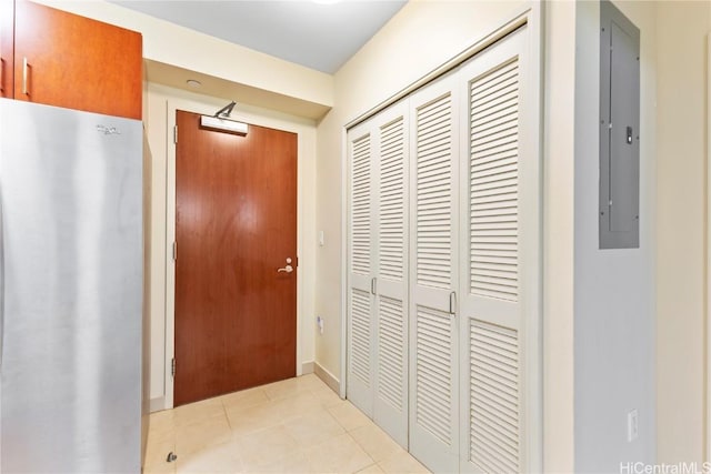 hall featuring light tile patterned flooring and electric panel