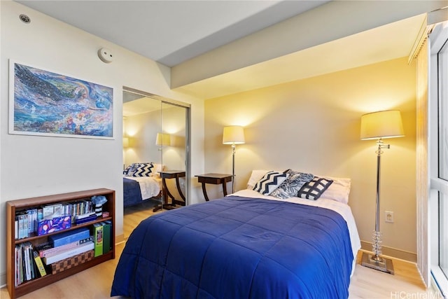 bedroom featuring a closet, wood finished floors, and baseboards