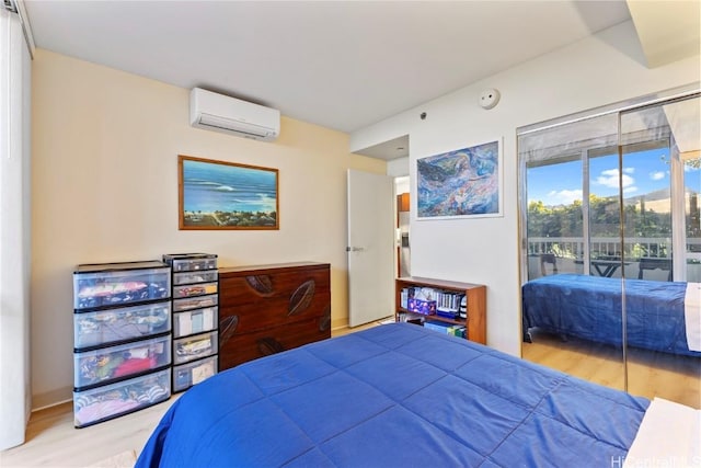 bedroom featuring a wall mounted AC, wood finished floors, and access to exterior