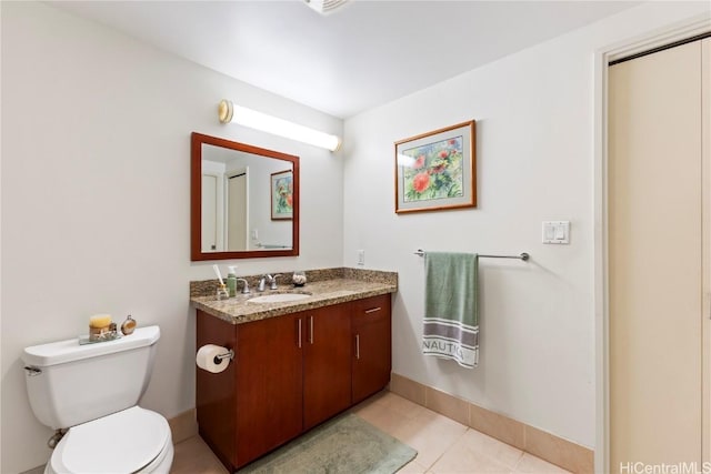 bathroom featuring tile patterned floors, vanity, toilet, and baseboards