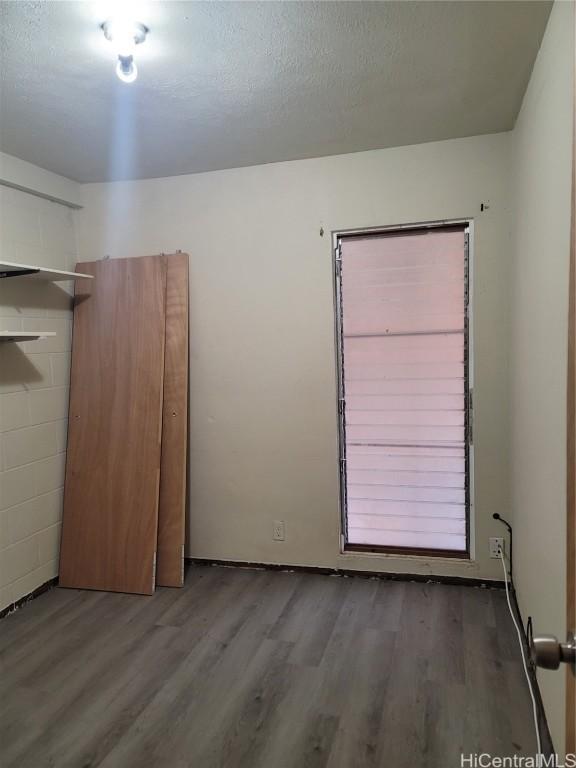 empty room featuring a textured ceiling and wood finished floors