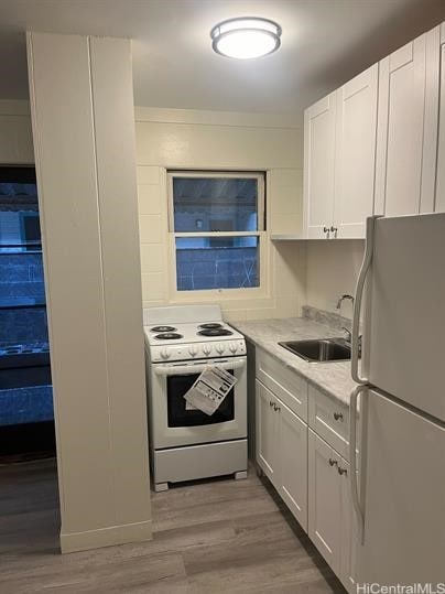 kitchen featuring white appliances, light wood-style floors, light countertops, and a sink