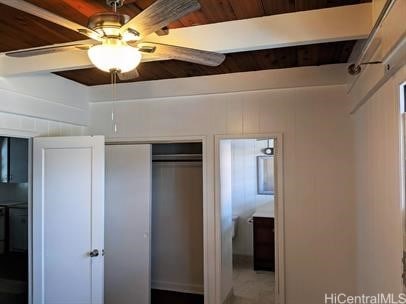 unfurnished bedroom with a closet, beam ceiling, and ceiling fan