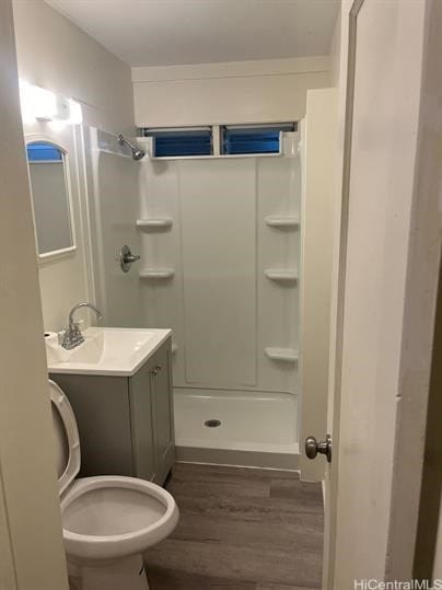 full bathroom featuring a stall shower, vanity, toilet, and wood finished floors