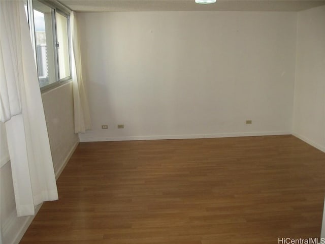 empty room featuring baseboards and wood finished floors