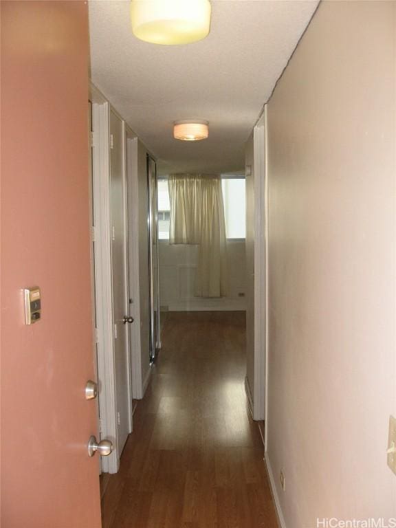 hallway with wood finished floors and baseboards