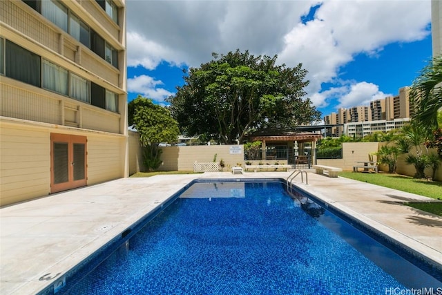 pool with french doors, a patio area, and a fenced backyard