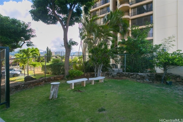 view of community featuring fence and a yard