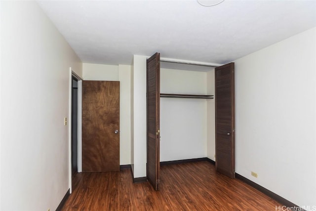 unfurnished bedroom featuring a closet, baseboards, and wood finished floors