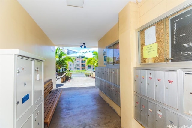 hallway with mail area and concrete flooring