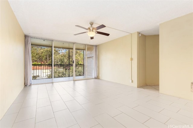 spare room with floor to ceiling windows and ceiling fan